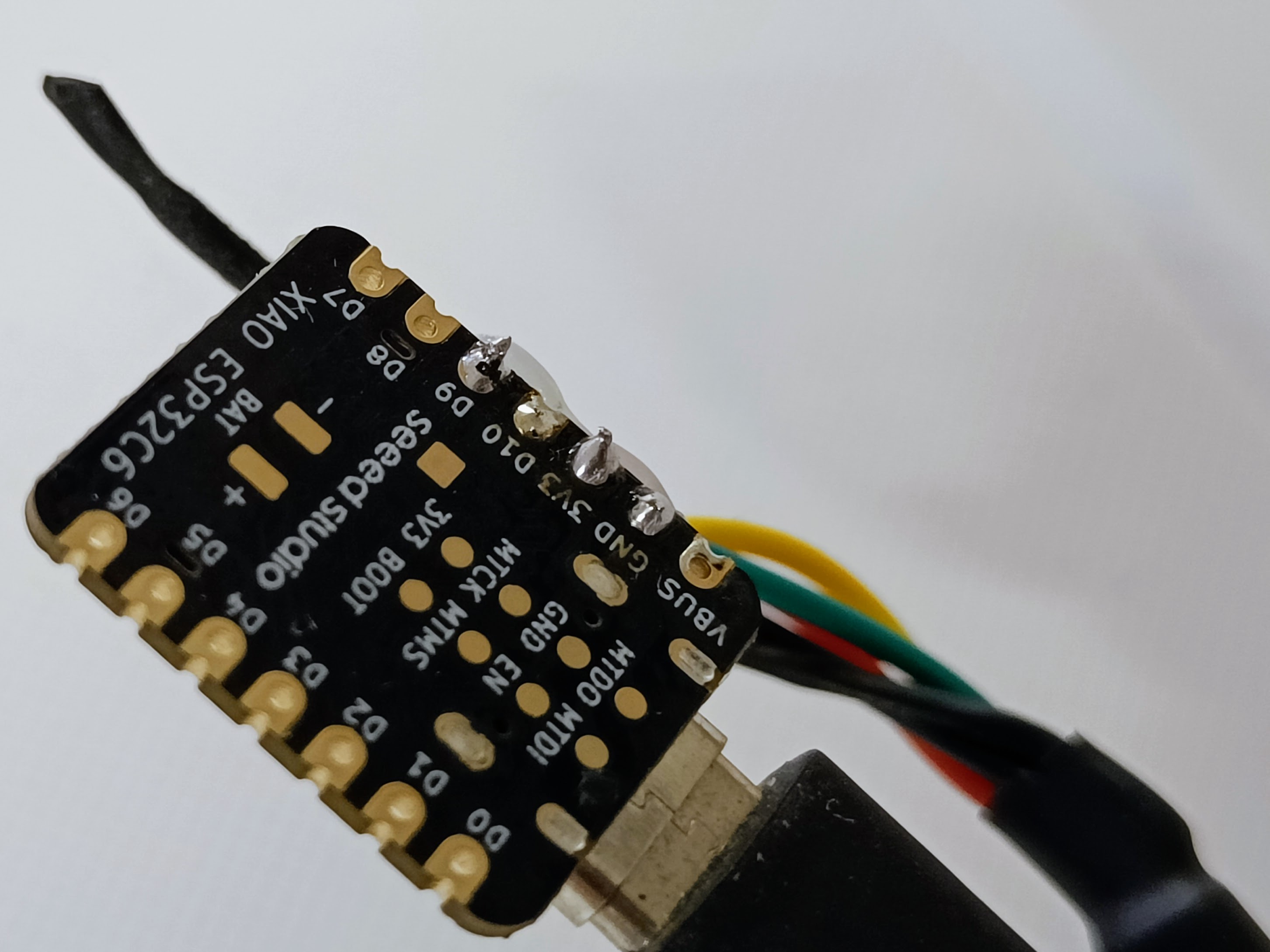 Underside of a Seeed Studio XIAO ESP32C6 showing the sensor wires soldered to its pins